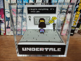 A collectible from the game Undertale, featuring a character on a platform with the text 'Despite everything, it’s still you.'.